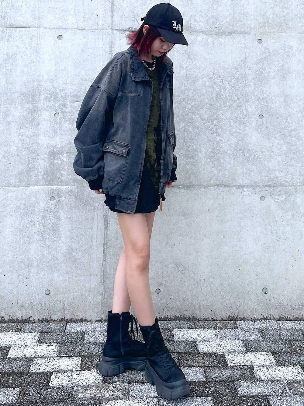 ブラック系のデニムジャケット、グリーン系のニット/セーター、ブラック系のその他パンツを着用したレディースの春コーディネートの3枚目の写真