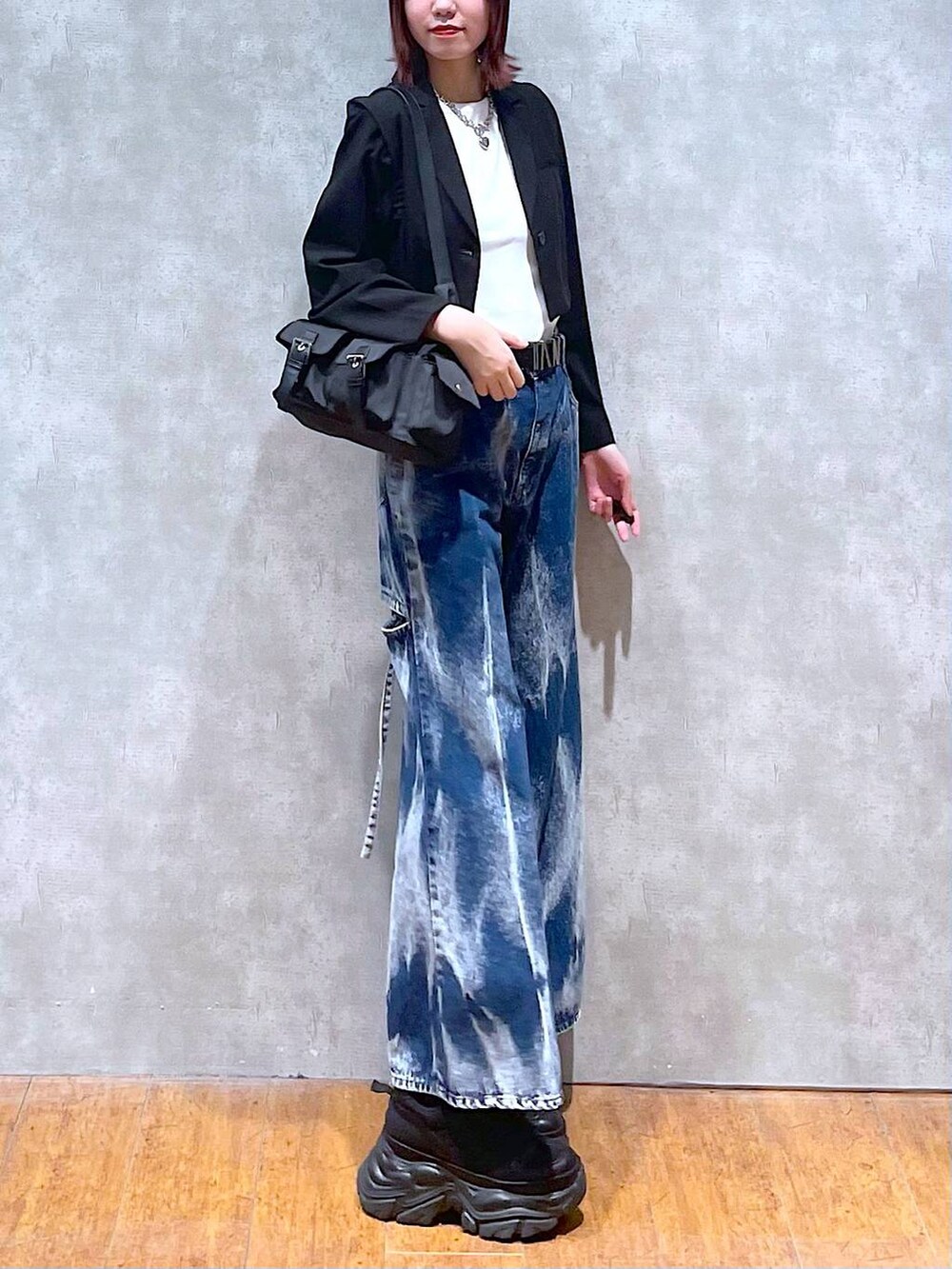 ブラック系のショルダーバッグ、ブラック系のスニーカー、ブラック系のテーラードジャケットを着用したレディースの春コーディネートの3枚目の写真