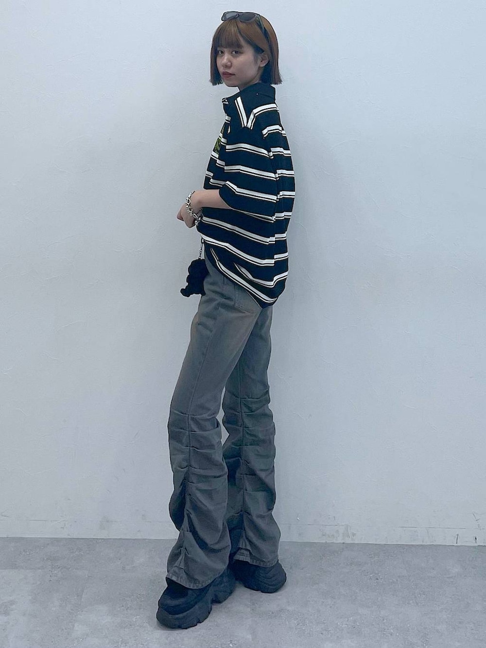 ブラック系のスニーカー、ブラック系のTシャツ/カットソー、ブルー系のデニムパンツを着用したレディースの夏コーディネートの5枚目の写真