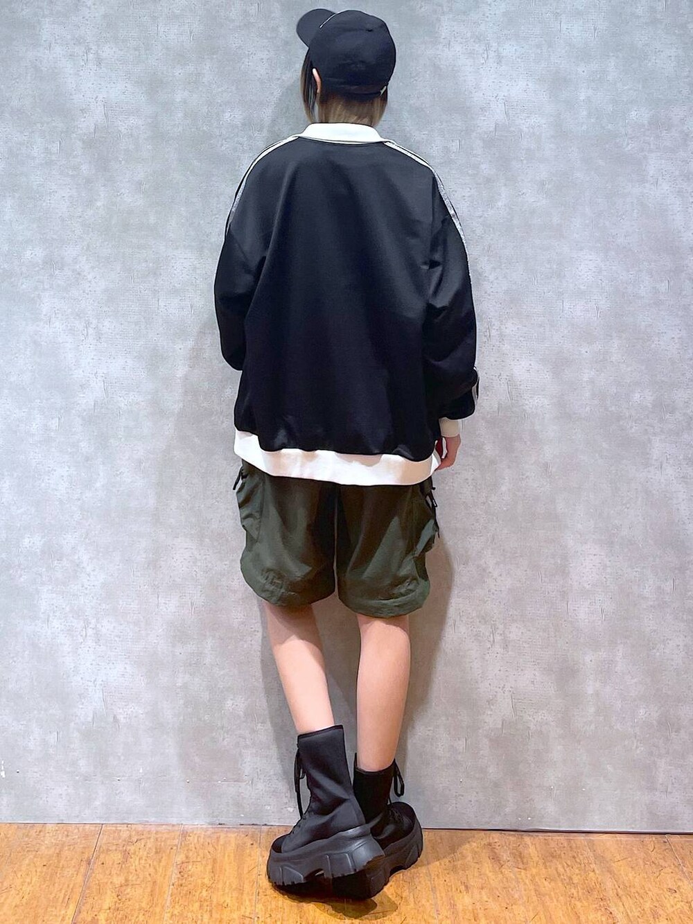 ブラック系のその他アウター、グリーン系のカーゴパンツ、ブラック系のブーツを着用したレディースの冬コーディネートの7枚目の写真