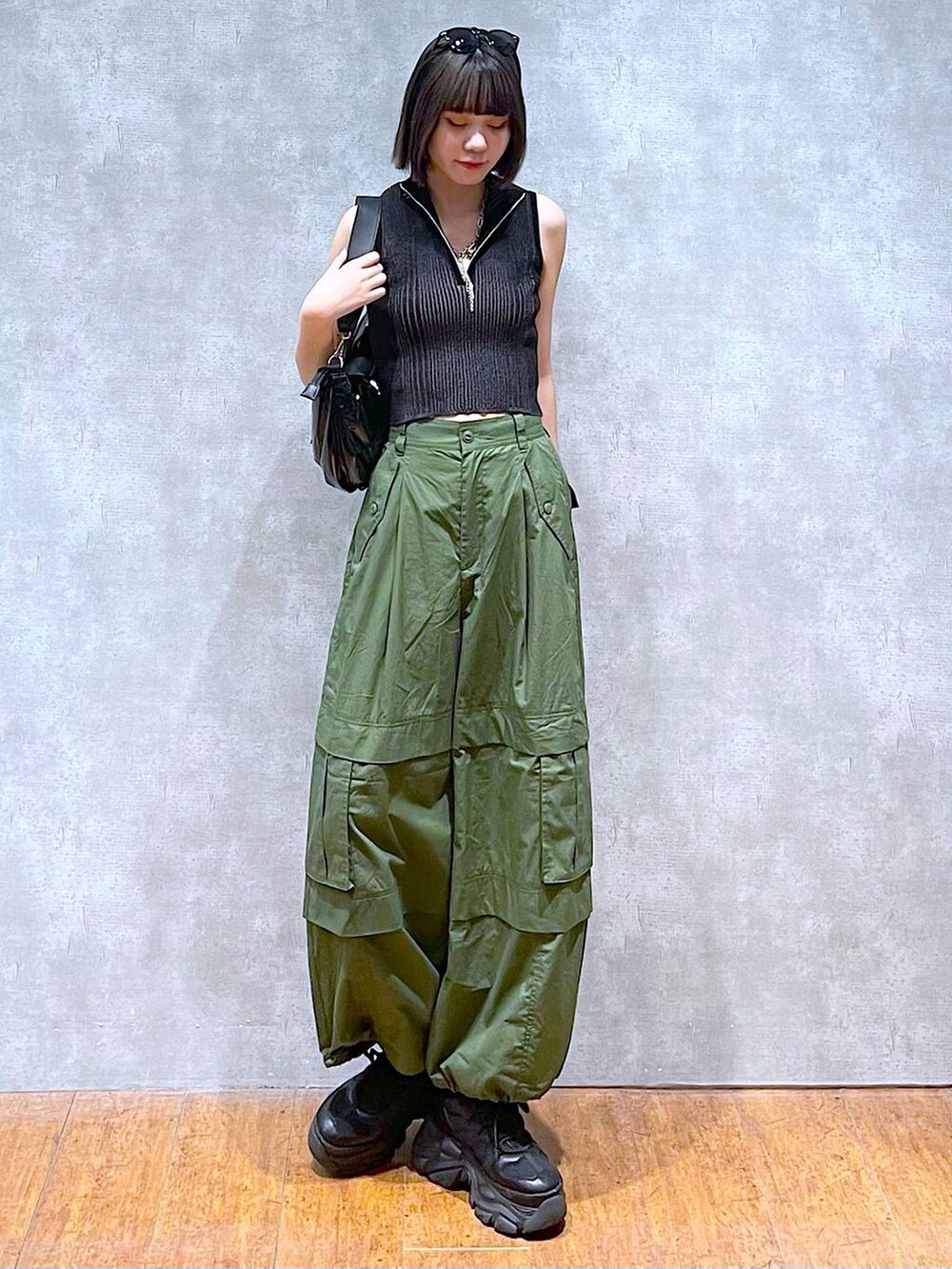 ブラック系のスニーカー、ブラック系のニット/セーター、グリーン系のその他パンツを着用したレディースの夏コーディネートの7枚目の写真