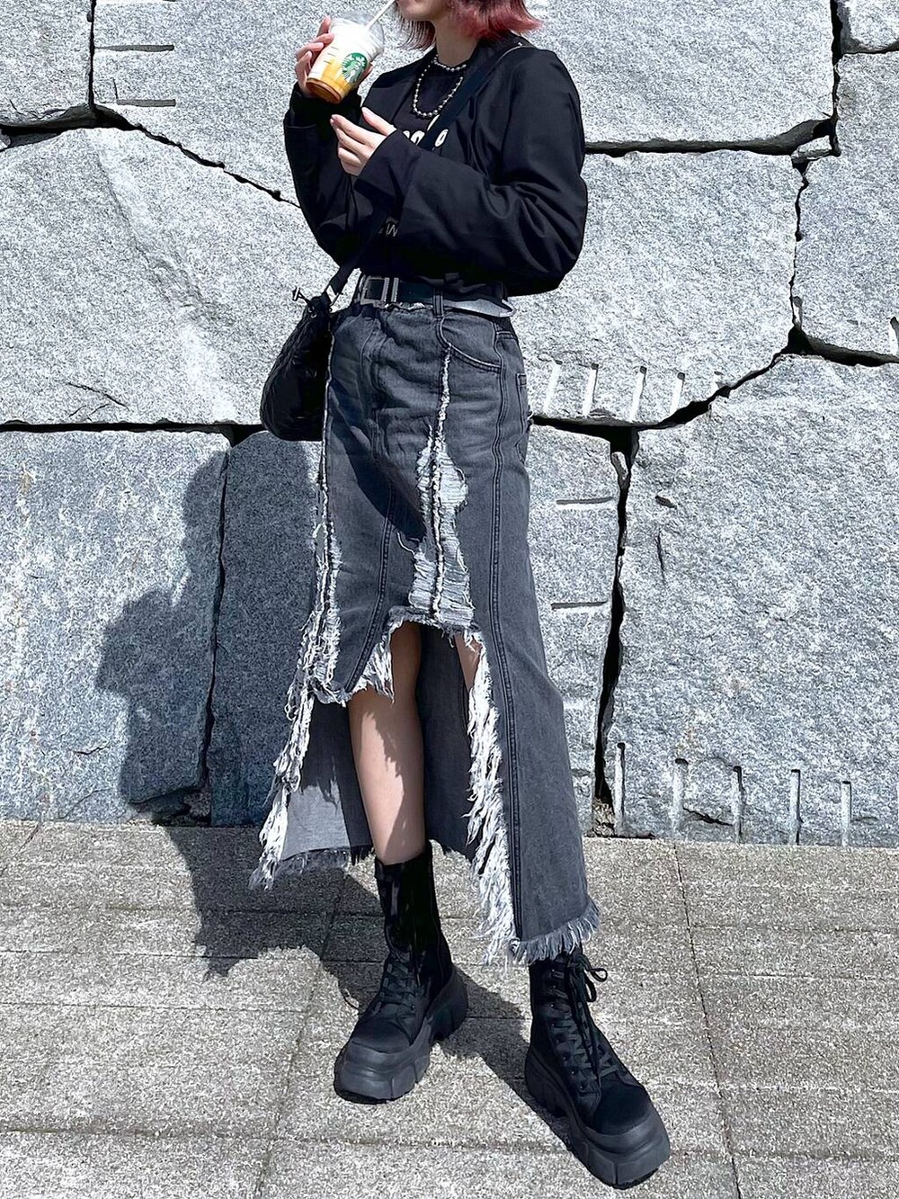 ブラック系のショルダーバッグ、ブラック系のブーツ、ブラック系のデニムスカートを着用したレディースの春コーディネートの2枚目の写真