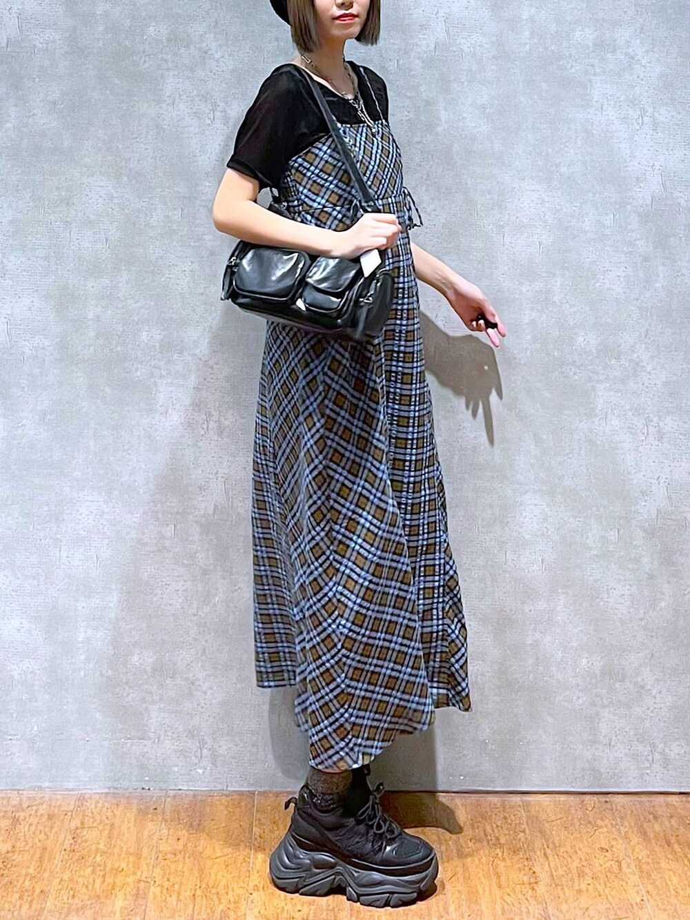 ブラック系のスニーカー、ブラック系のショルダーバッグ、ブルー系のワンピースを着用したレディースの秋コーディネートの6枚目の写真