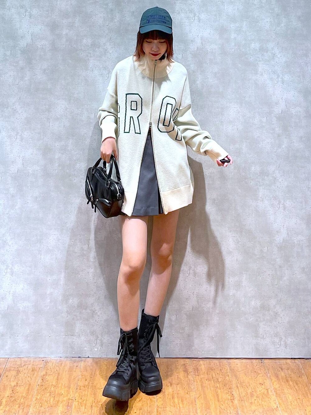 ベージュ系のニット/セーター、グレー系のその他パンツ、ブラック系のブーツを着用したレディースの春コーディネートの2枚目の写真