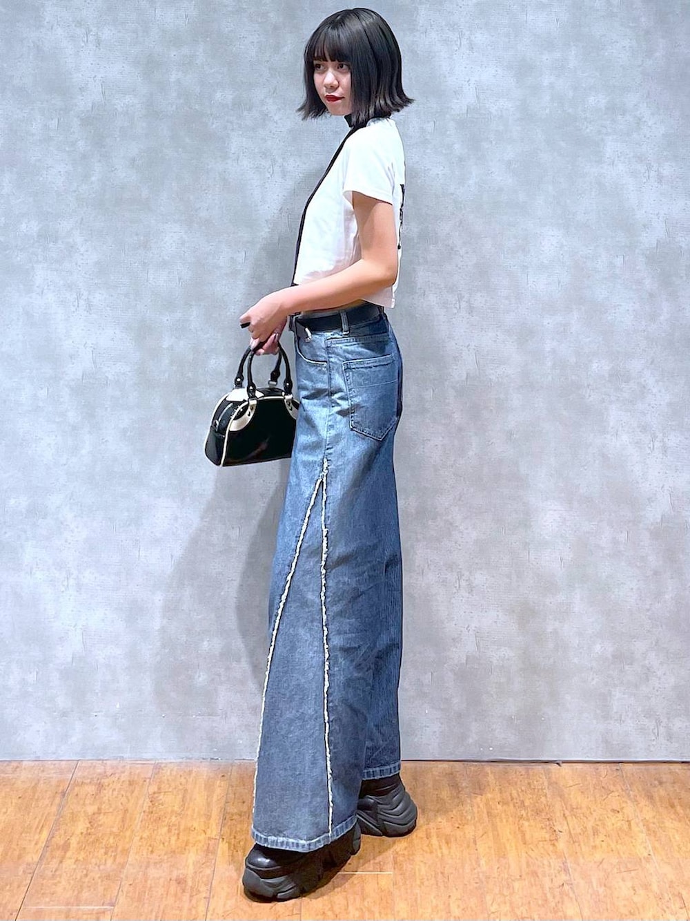 ブラック系のスニーカー、ホワイト系のTシャツ/カットソー、ブラック系のネクタイを着用したレディースの夏コーディネートの5枚目の写真