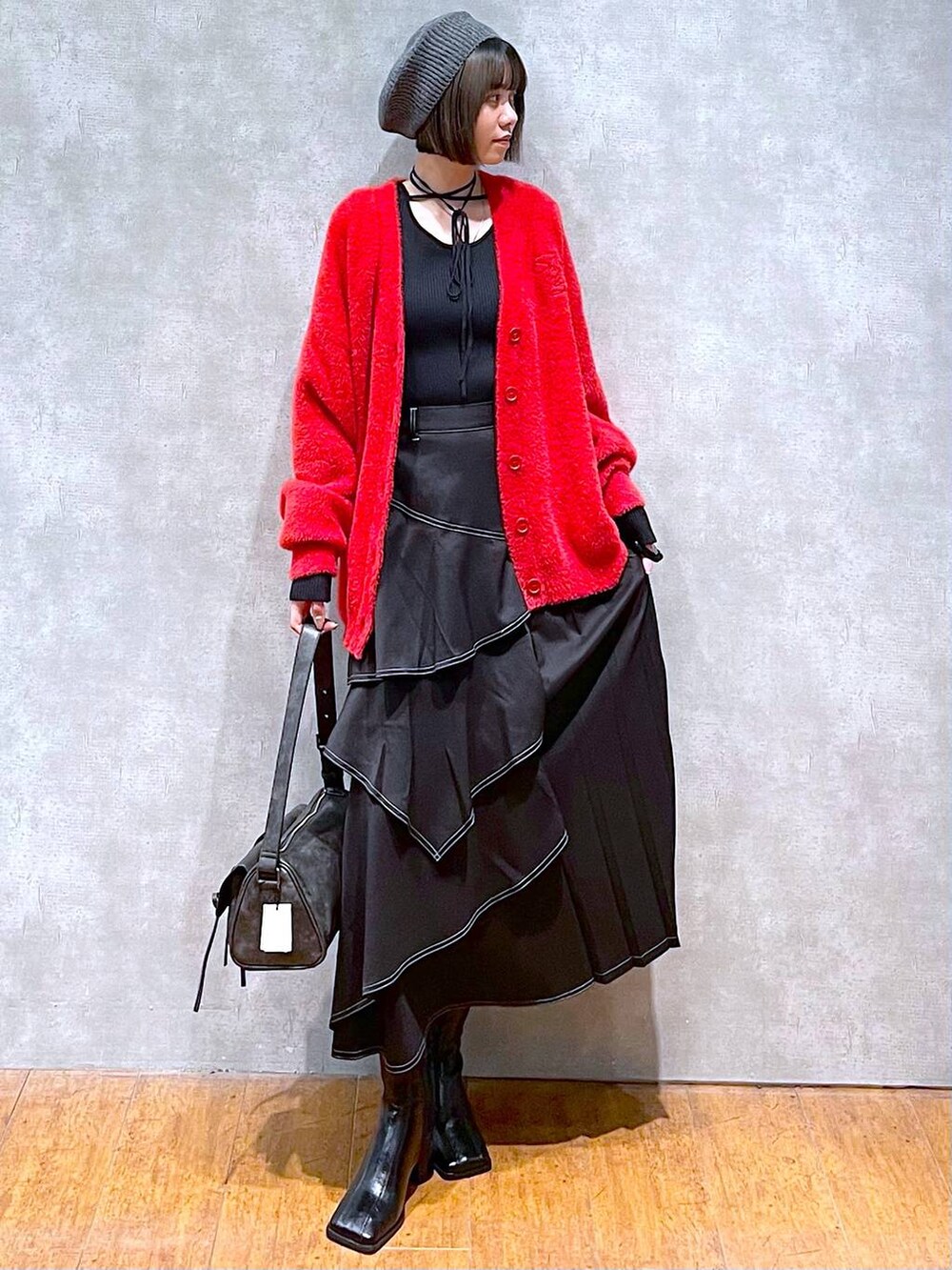 ブラック系のショルダーバッグ、ブラック系のブーツ、ブラック系のスカートを着用したレディースの秋コーディネートの8枚目の写真