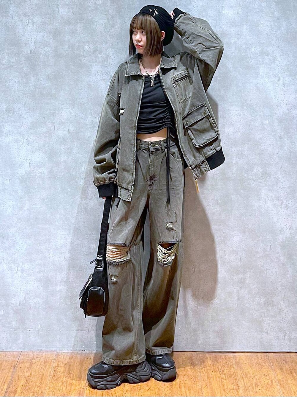 ブラック系のスニーカー、ブラック系のTシャツ/カットソー、ブラック系のブルゾンを着用したレディースの秋コーディネートの2枚目の写真