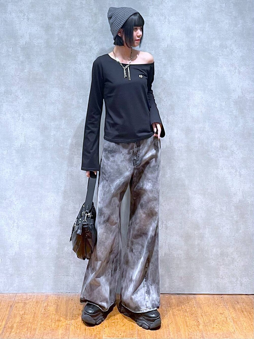 ブラック系のスニーカー、ブラック系のショルダーバッグ、ブラック系のデニムパンツを着用したレディースの夏コーディネートの7枚目の写真