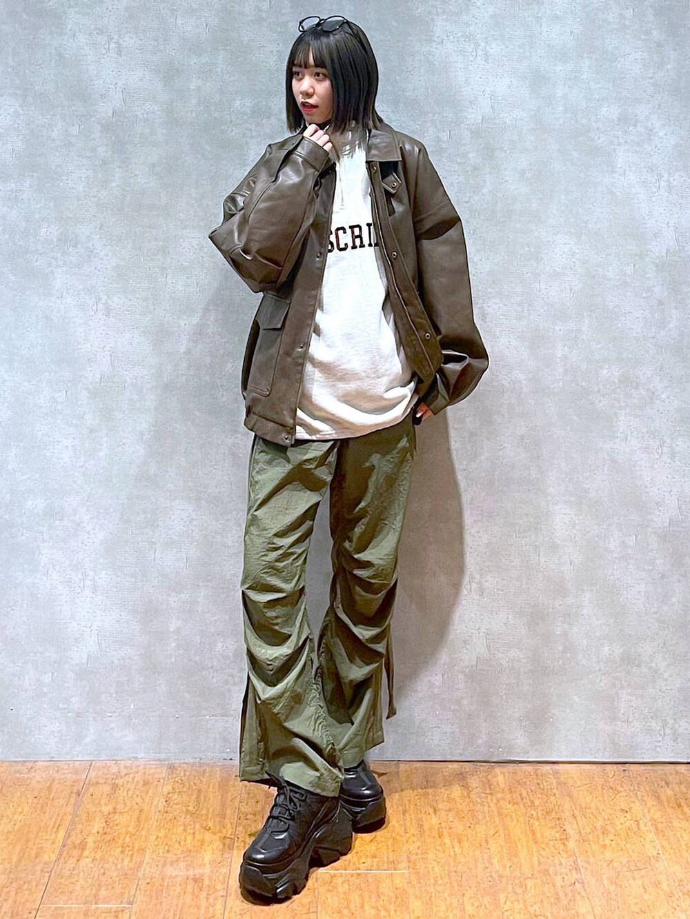 ブラック系のスニーカー、グリーン系のカーゴパンツ、ブラウン系のブルゾンを着用したレディースの秋コーディネートの4枚目の写真