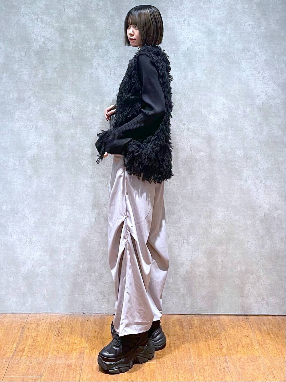 ブラック系のスニーカー、ブラック系のショルダーバッグ、グレー系のその他パンツを着用したレディースの秋コーディネートの5枚目の写真