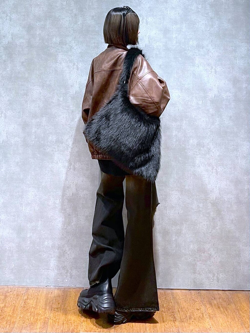 ブラウン系のブルゾン、ブラック系のブーツ、グレー系のスウェットを着用したレディースの秋コーディネートの6枚目の写真