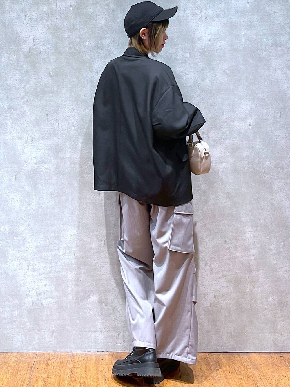 ブラック系のテーラードジャケット、ホワイト系のTシャツ/カットソー、ブラック系のブーツを着用したレディースの冬コーディネートの5枚目の写真