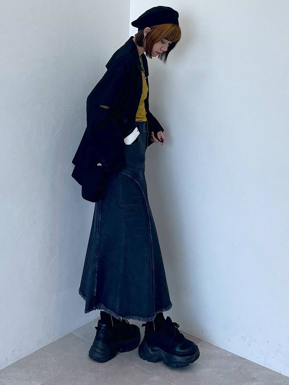 ブラック系のスニーカー、ブラック系のデニムスカート、イエロー系のTシャツ/カットソーを着用したレディースの夏コーディネートの4枚目の写真