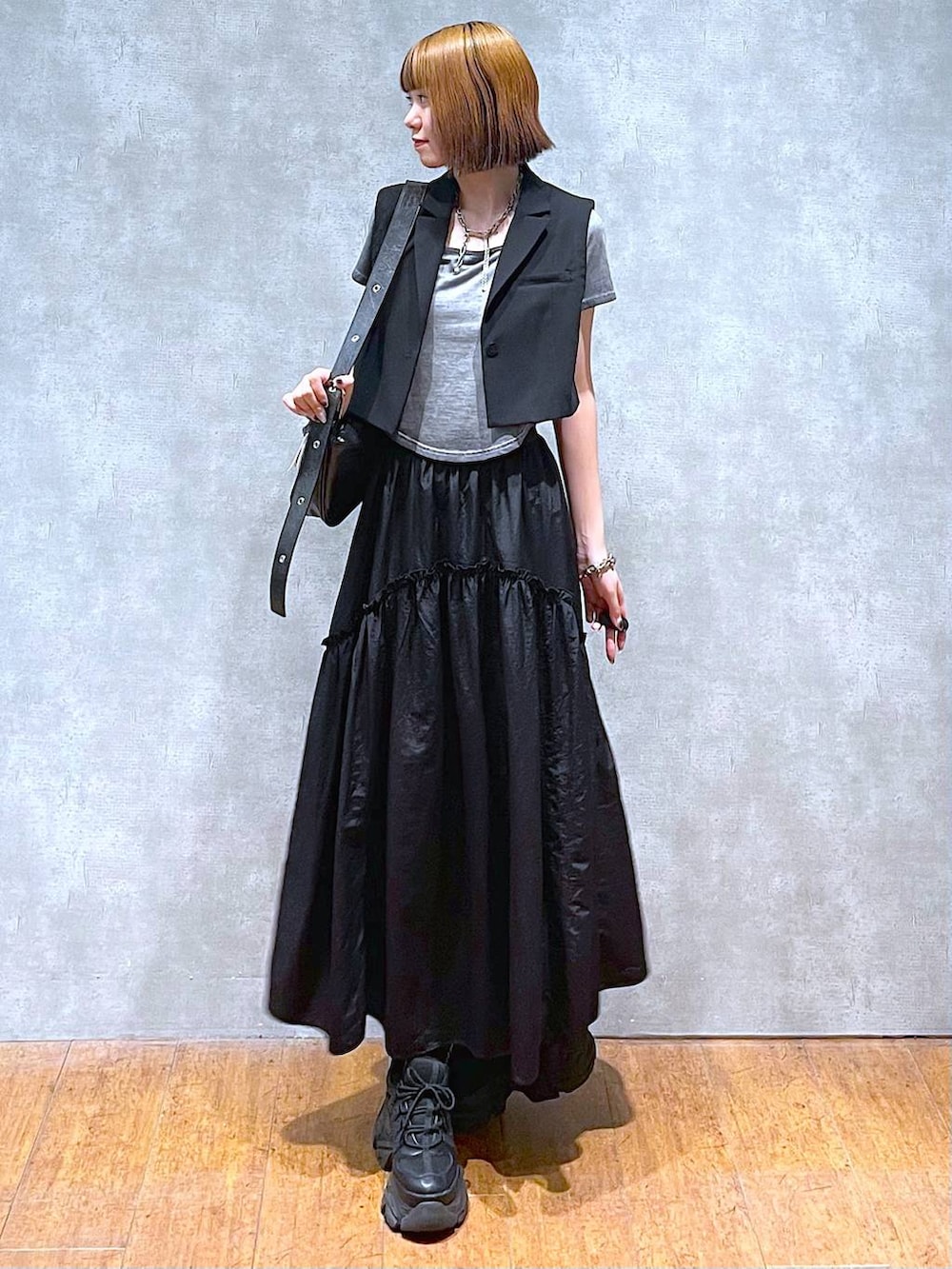 ブラック系のスニーカー、ブラック系のテーラードジャケット、グレー系のTシャツ/カットソーを着用したレディースの夏コーディネートの6枚目の写真