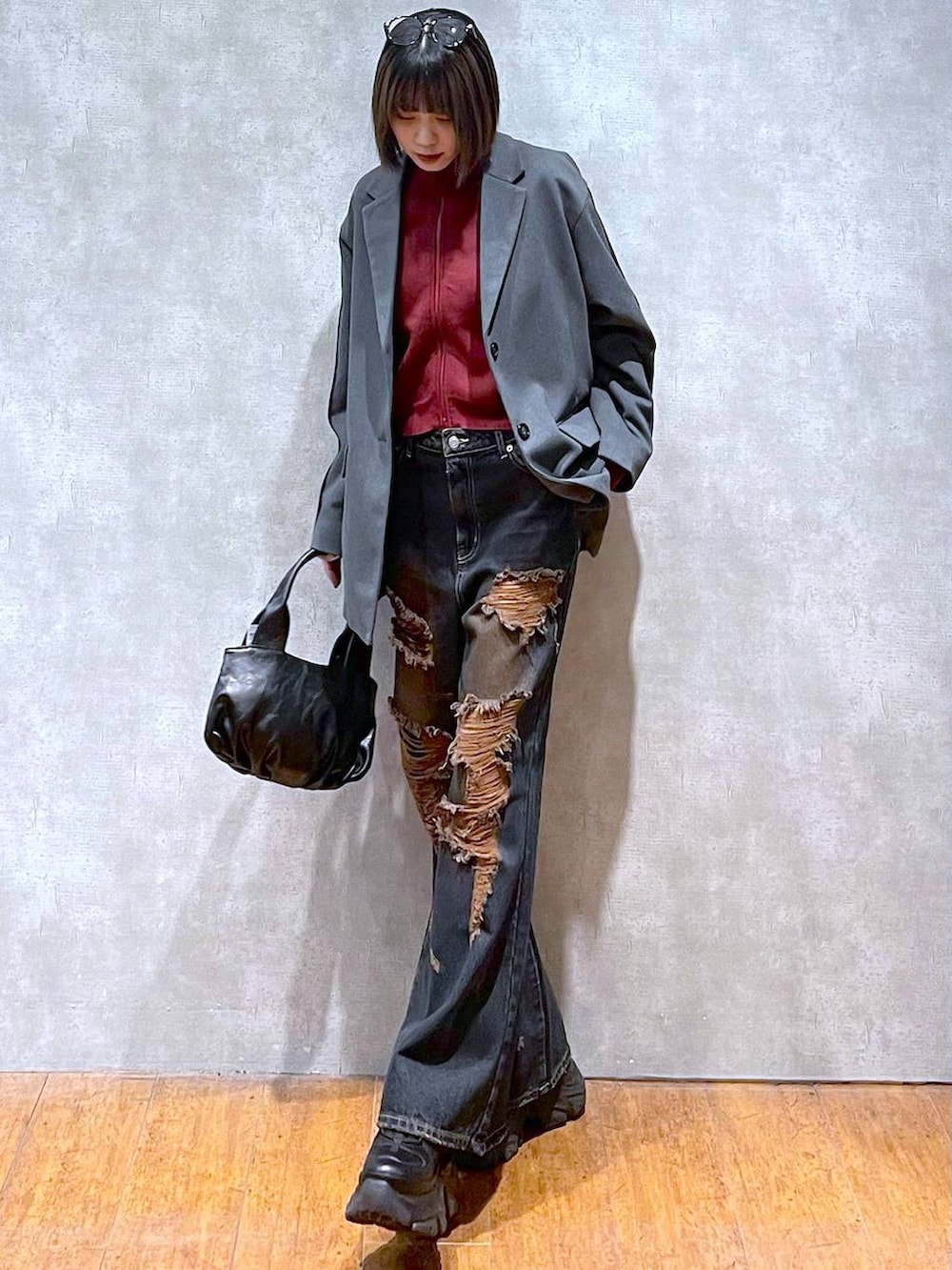 ブラック系のスニーカー、レッド系のニット/セーター、ブラック系のハンドバッグを着用したレディースの秋コーディネートの2枚目の写真