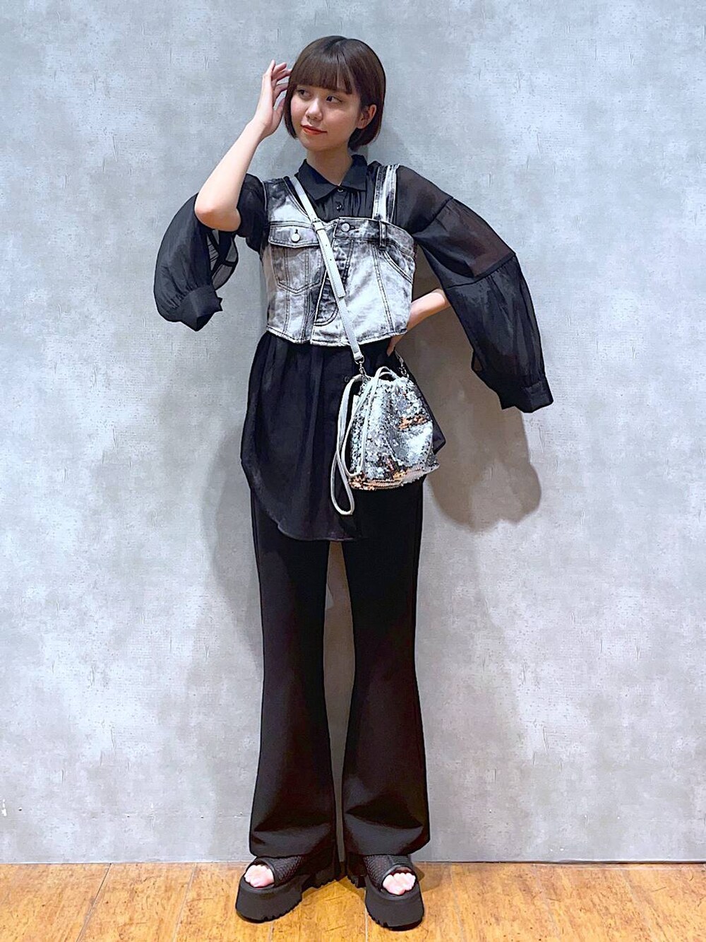 ブラック系のスラックス、ブラック系のベスト、シルバー系のショルダーバッグを着用したレディースの夏コーディネートの2枚目の写真