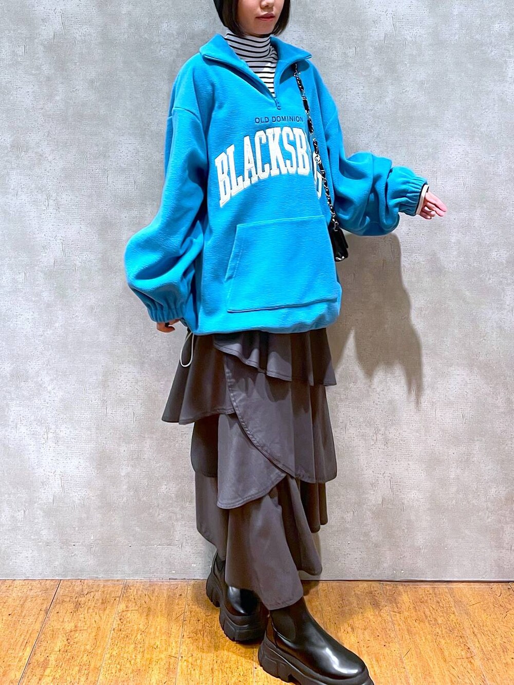 ブラック系のブーツ、グレー系のスカート、ホワイト系のTシャツ/カットソーを着用したレディースの冬コーディネートの3枚目の写真