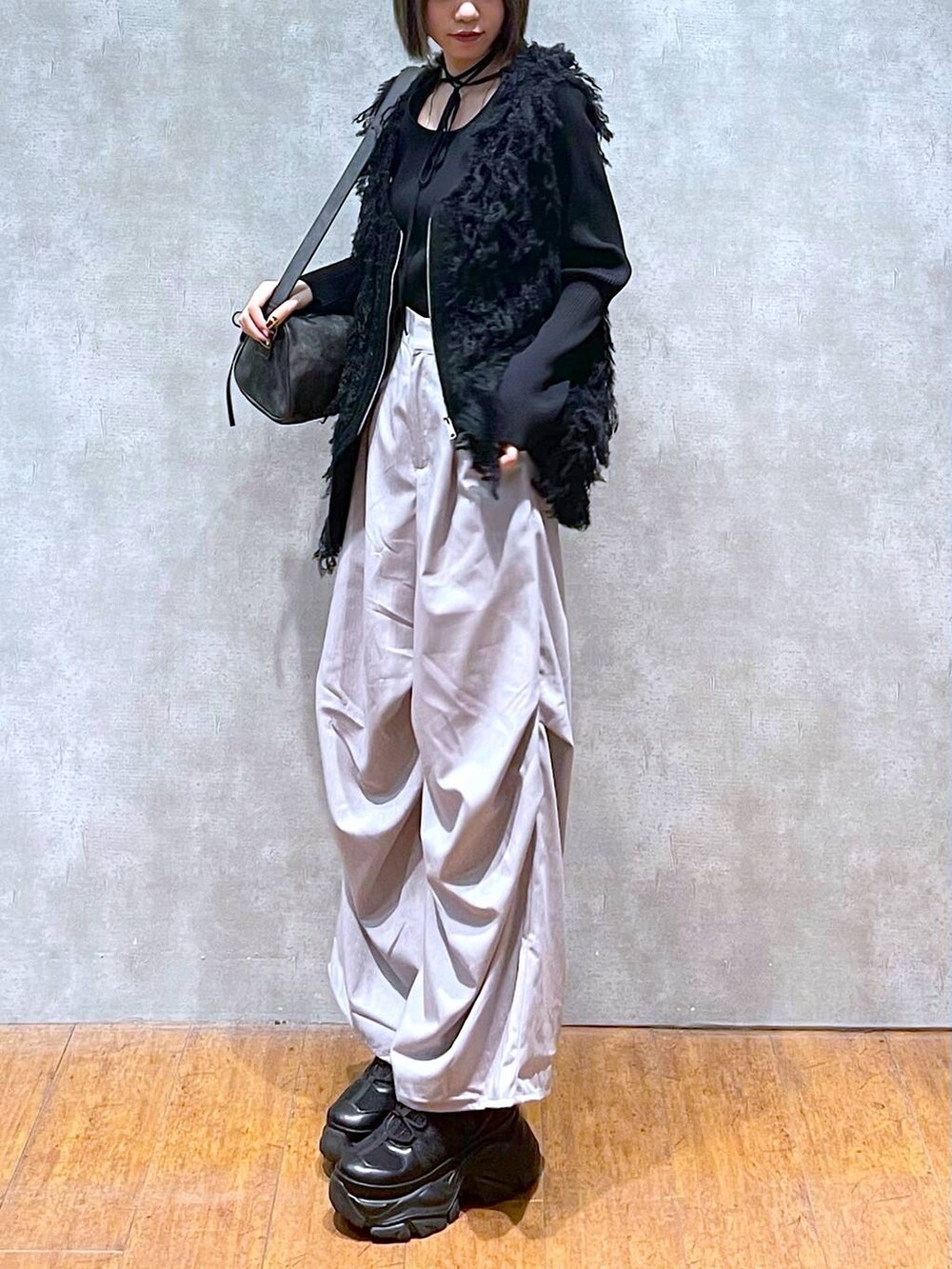 ブラック系のスニーカー、ブラック系のショルダーバッグ、グレー系のその他パンツを着用したレディースの秋コーディネートの6枚目の写真