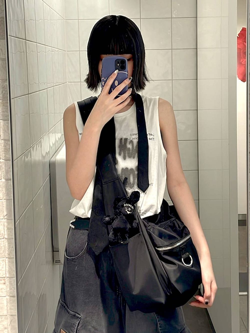 ブラック系のスニーカー、ブラック系のショルダーバッグ、ホワイト系のTシャツ/カットソーを着用したレディースの夏コーディネートの2枚目の写真