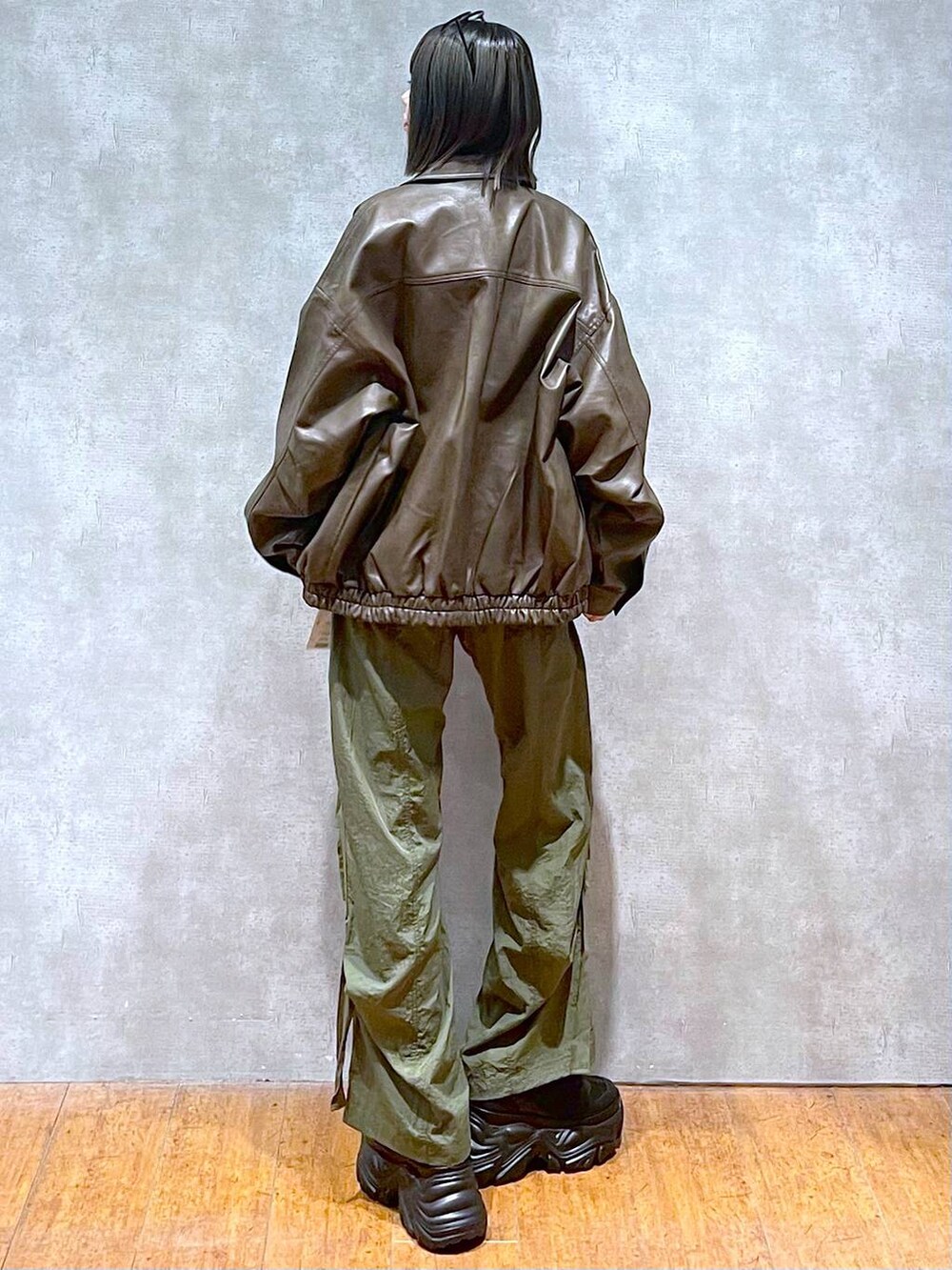 ブラック系のスニーカー、グリーン系のカーゴパンツ、ブラウン系のブルゾンを着用したレディースの秋コーディネートの7枚目の写真