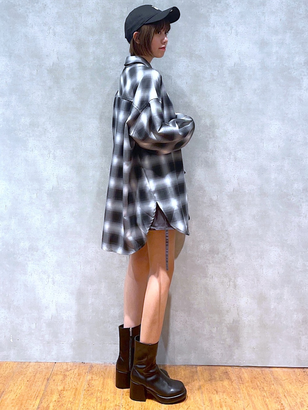 グレー系のスカート、ホワイト系のTシャツ/カットソー、ブラック系のシャツ/ブラウスを着用したレディースの秋コーディネートの2枚目の写真