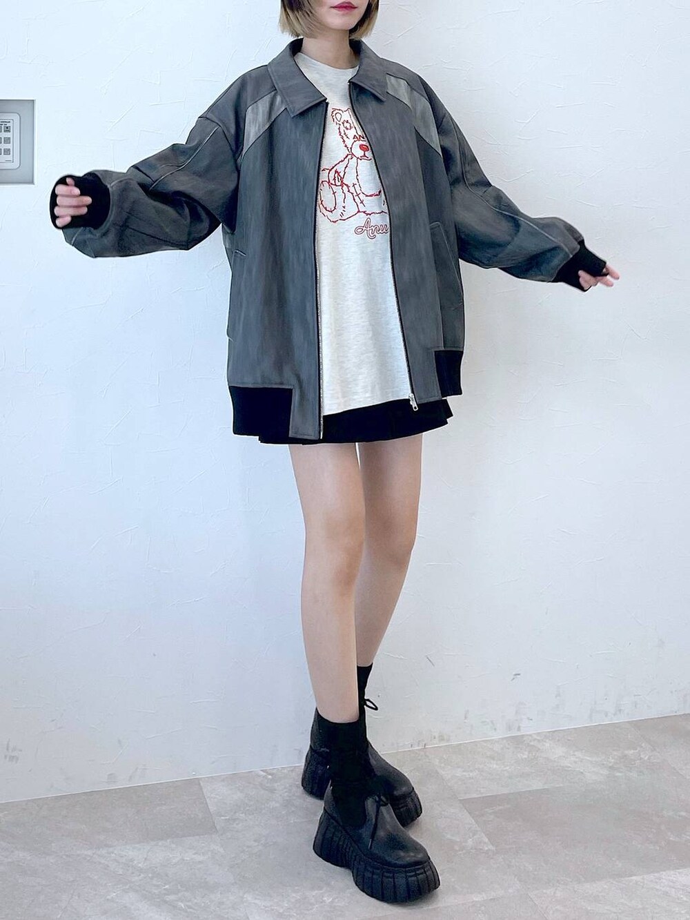グレー系のブルゾン、ブラック系のその他パンツ、ブラック系のブーツを着用したレディースの冬コーディネートの2枚目の写真