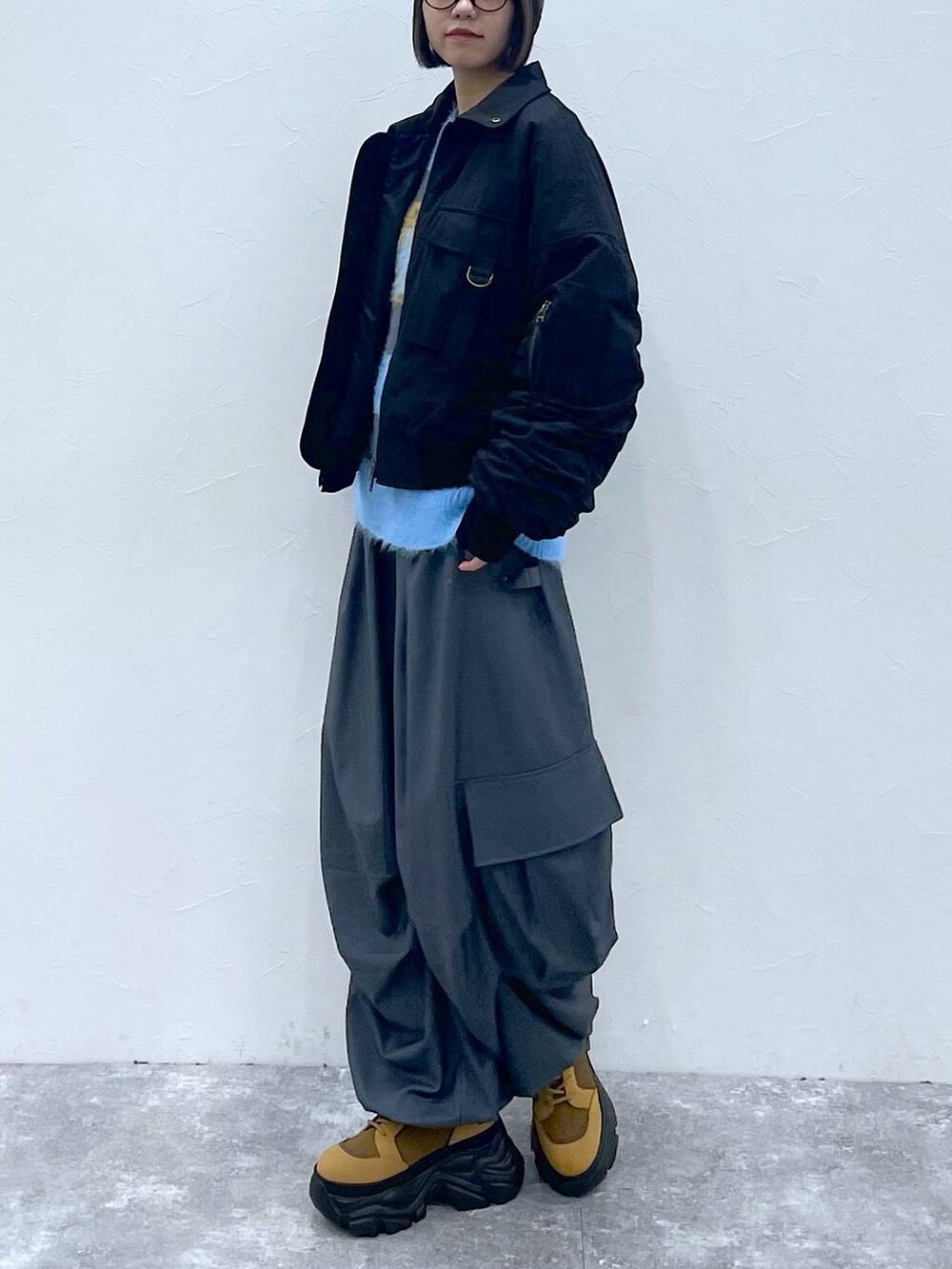 ブラウン系のブーツ、ブラック系のブルゾン、グレー系のカーゴパンツを着用したレディースの秋コーディネートの3枚目の写真