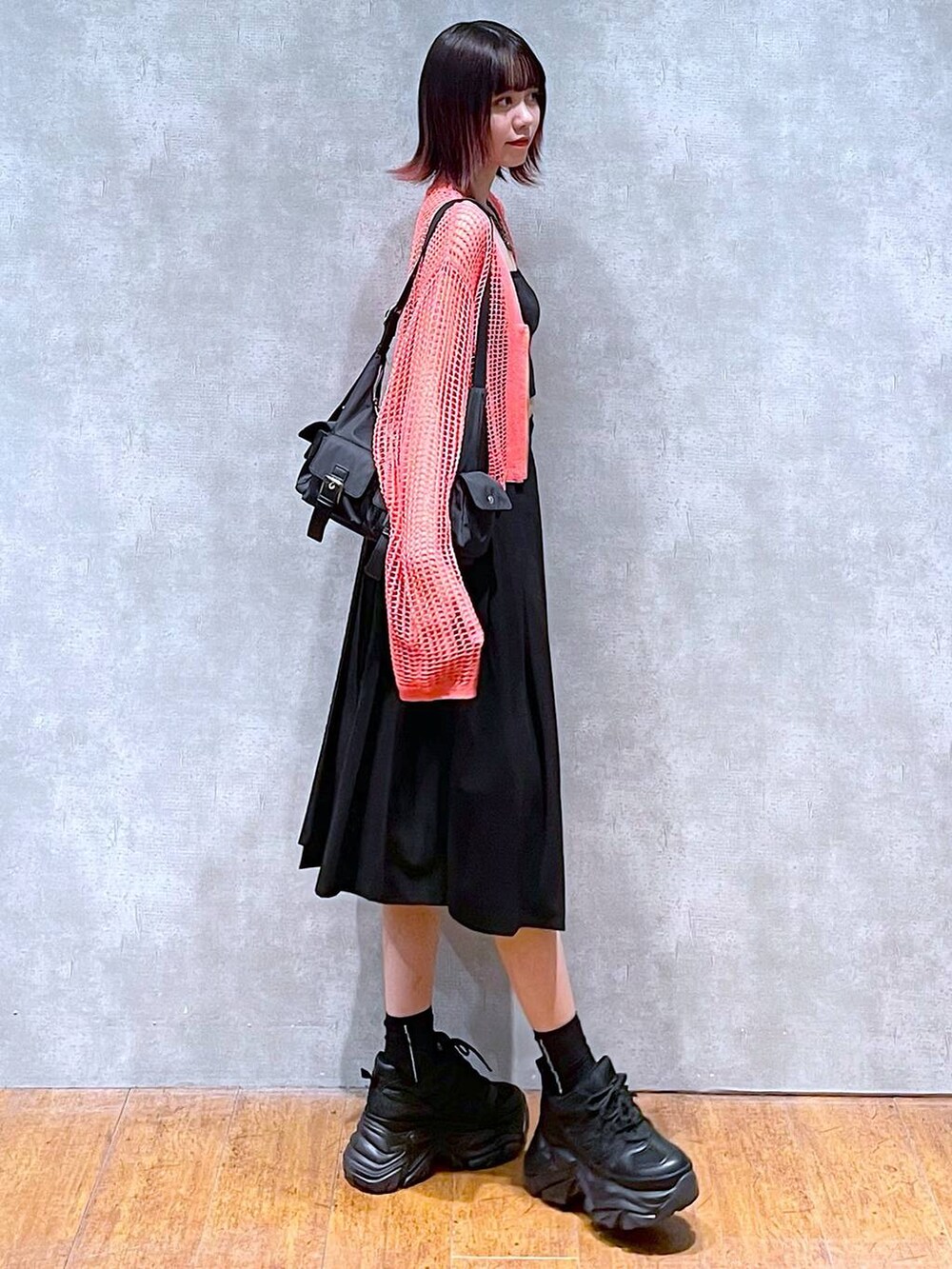 ブラック系のショルダーバッグ、ピンク系のカーディガン/ボレロ、ブラック系のキャミソールを着用したレディースの春コーディネートの4枚目の写真