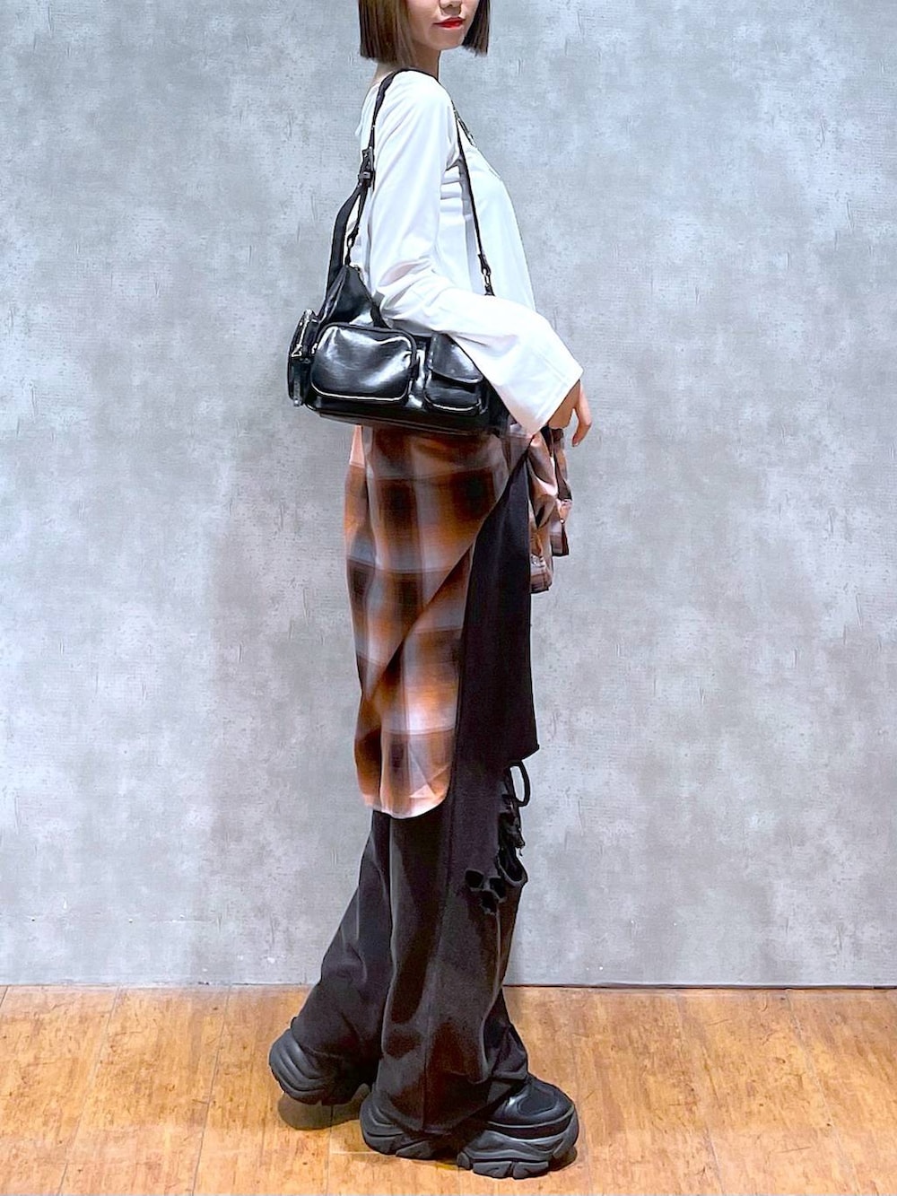 ブラック系のスニーカー、ブラック系のその他パンツ、オレンジ系のシャツ/ブラウスを着用したレディースの秋コーディネートの6枚目の写真