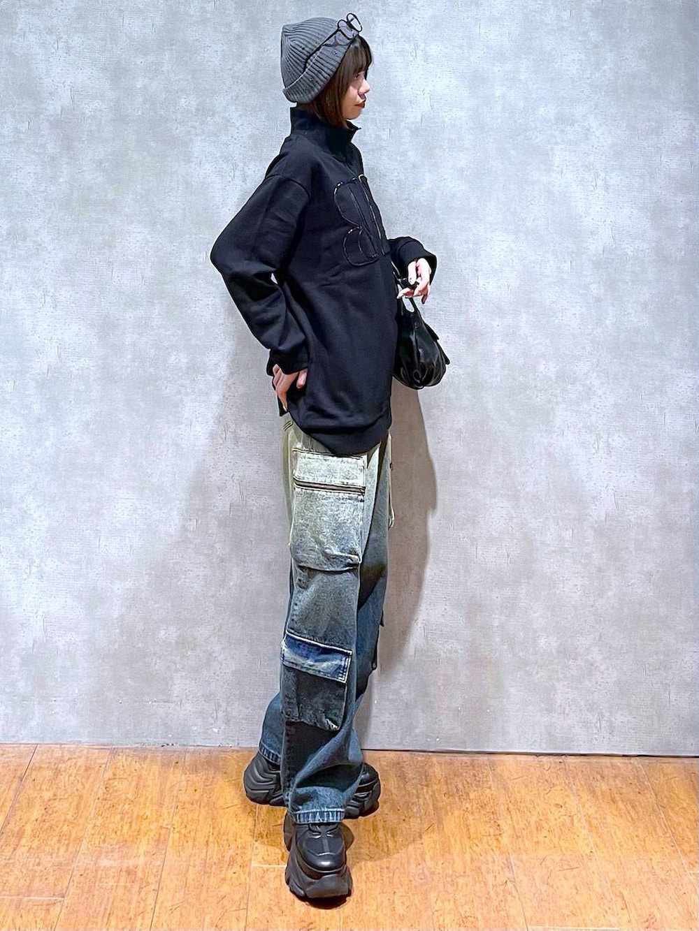 ブラック系のスニーカー、ブルー系のデニムパンツ、ブラック系のハンドバッグを着用したレディースの秋コーディネートの6枚目の写真