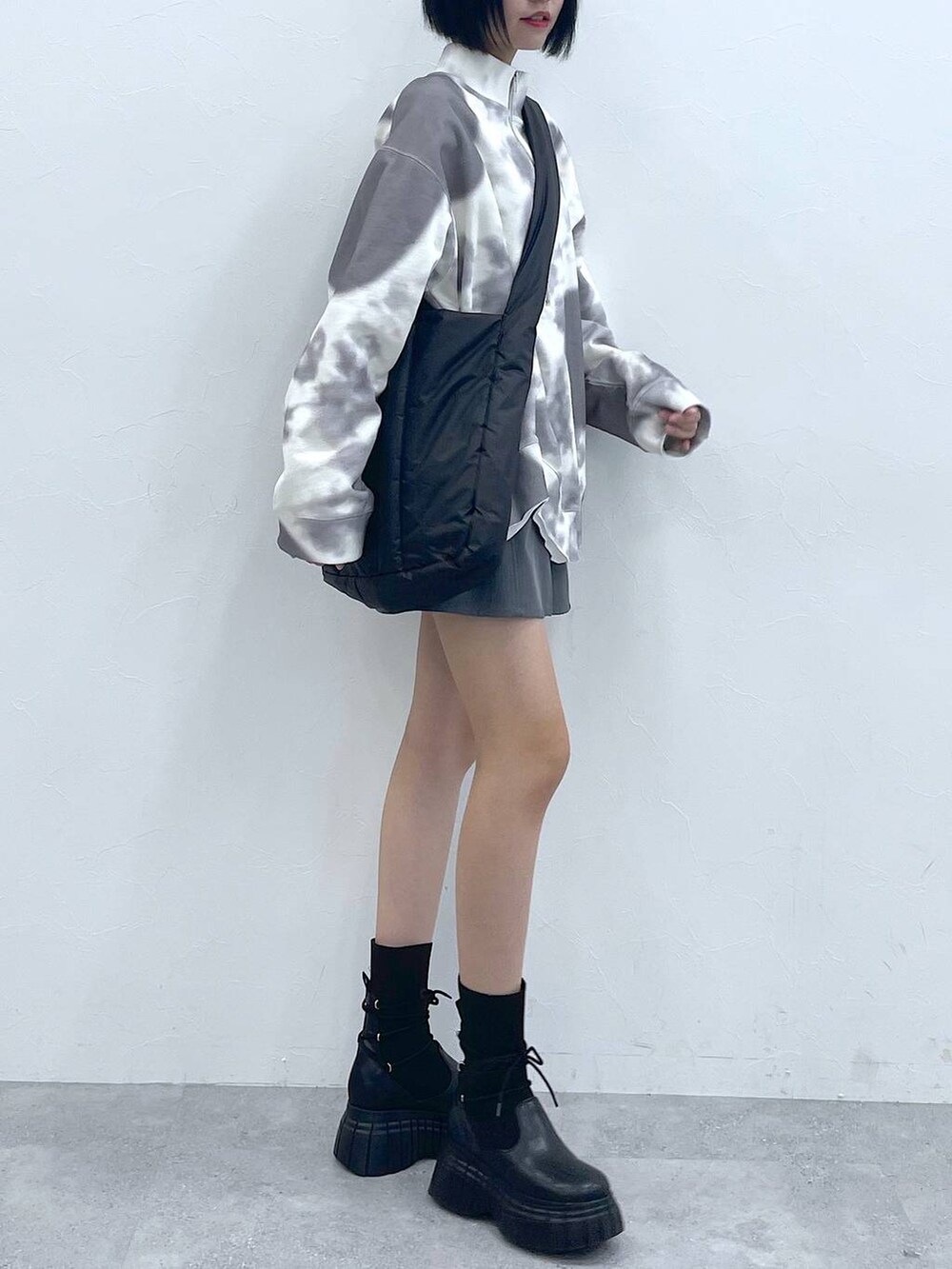 ブラック系のトートバッグ、ブラック系のブーツ、ホワイト系のTシャツ/カットソーを着用したレディースの冬コーディネートの2枚目の写真