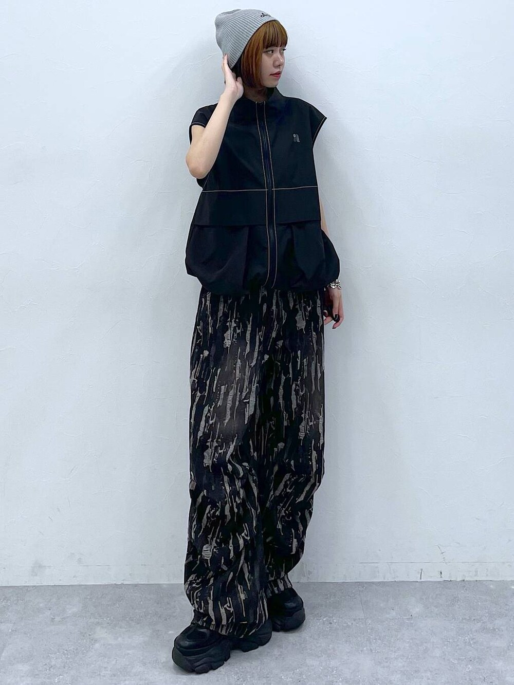 ブラック系のスニーカー、ブラック系のベスト、ブラック系のデニムパンツを着用したレディースの夏コーディネートの6枚目の写真