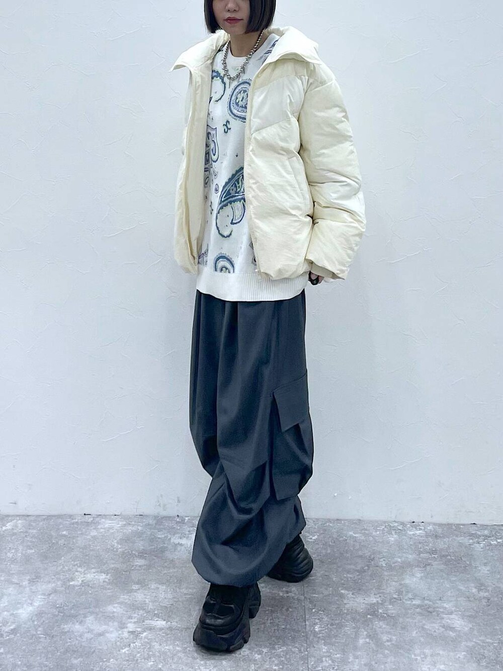 ブラック系のスニーカー、グレー系のカーゴパンツ、ホワイト系のブルゾンを着用したレディースの秋コーディネートの3枚目の写真