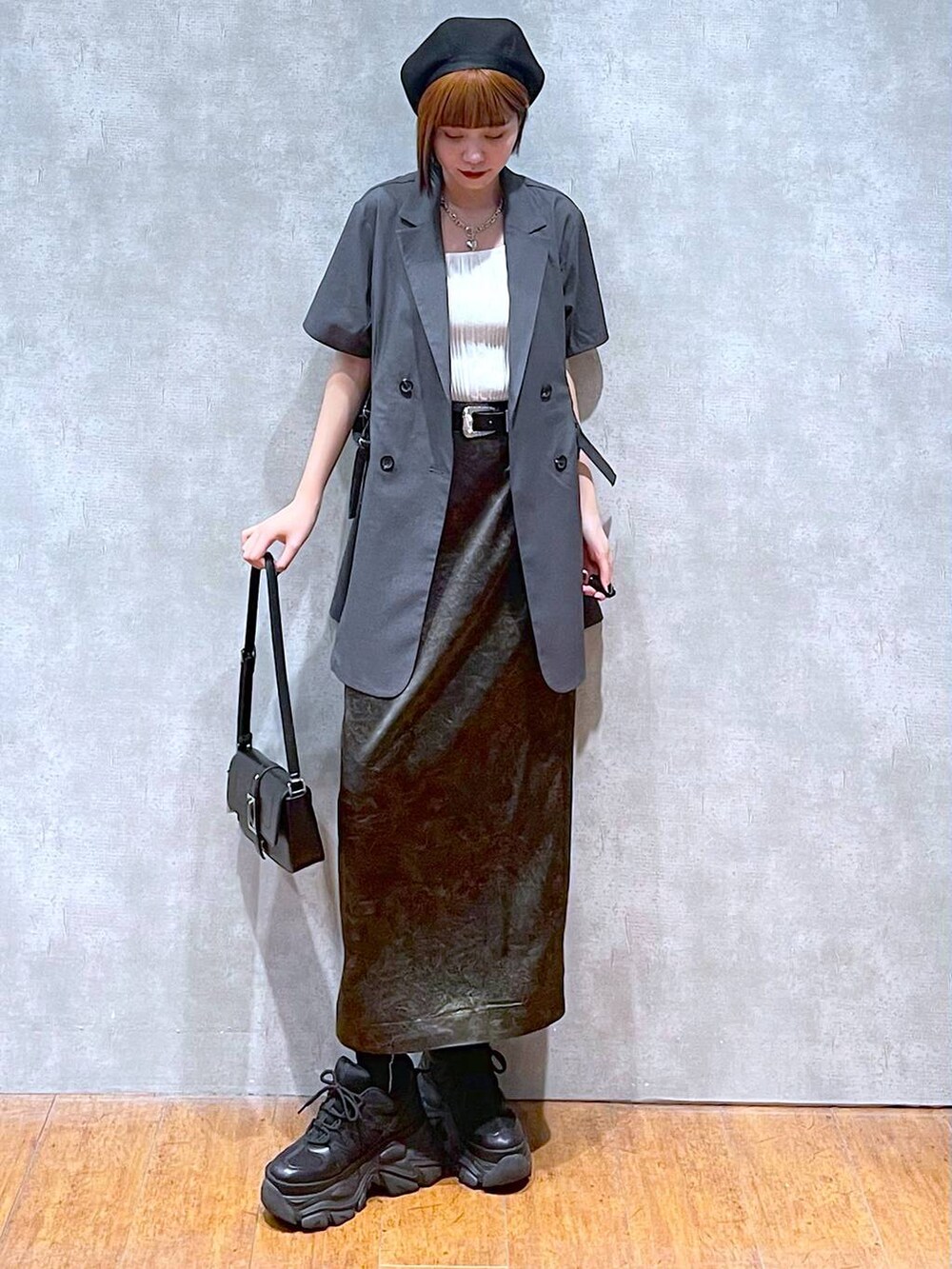 ホワイト系のタンクトップ、ブラック系のスニーカー、ブラック系のハンドバッグを着用したレディースの夏コーディネートの2枚目の写真