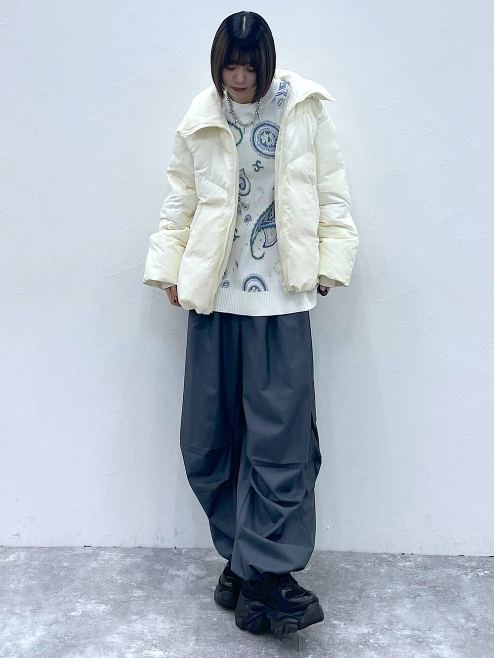 ブラック系のスニーカー、グレー系のカーゴパンツ、ホワイト系のブルゾンを着用したレディースの秋コーディネートの7枚目の写真