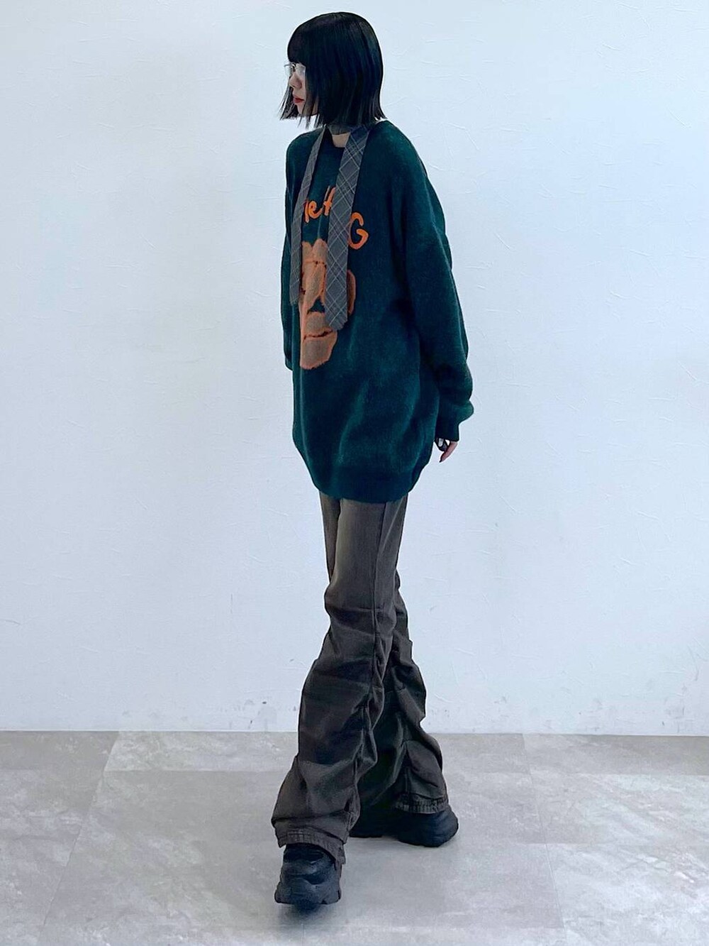 ブラック系のスニーカー、グレー系のネクタイ、ブラック系のデニムパンツを着用したレディースの秋コーディネートの7枚目の写真