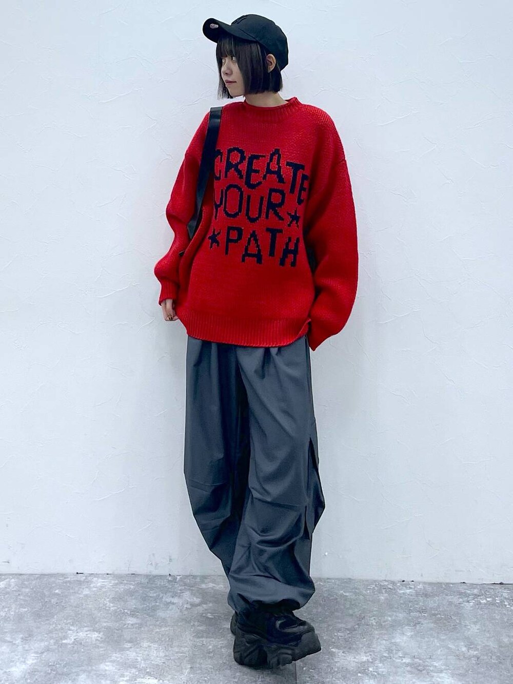 ブラック系のショルダーバッグ、ブラック系のスニーカー、グレー系のカーゴパンツを着用したレディースの秋コーディネートの2枚目の写真