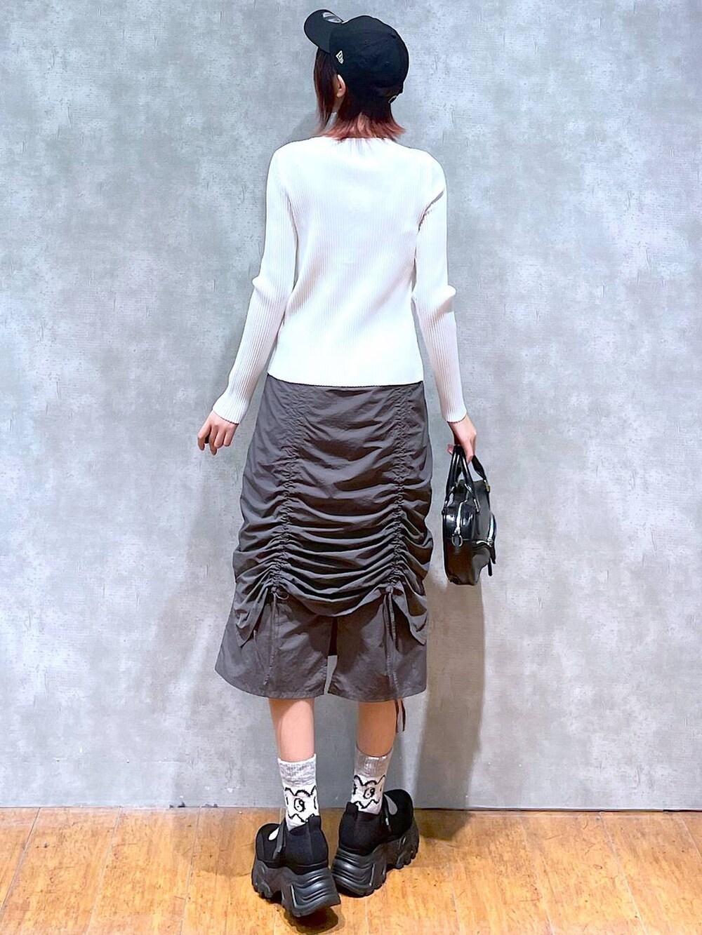 ホワイト系のニット/セーター、ホワイト系のキャミソール、ブラック系のボストンバッグを着用したレディースの春コーディネートの5枚目の写真