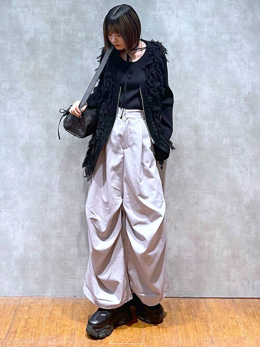 ブラック系のスニーカー、ブラック系のショルダーバッグ、グレー系のその他パンツを着用したレディースの秋コーディネートの9枚目の写真