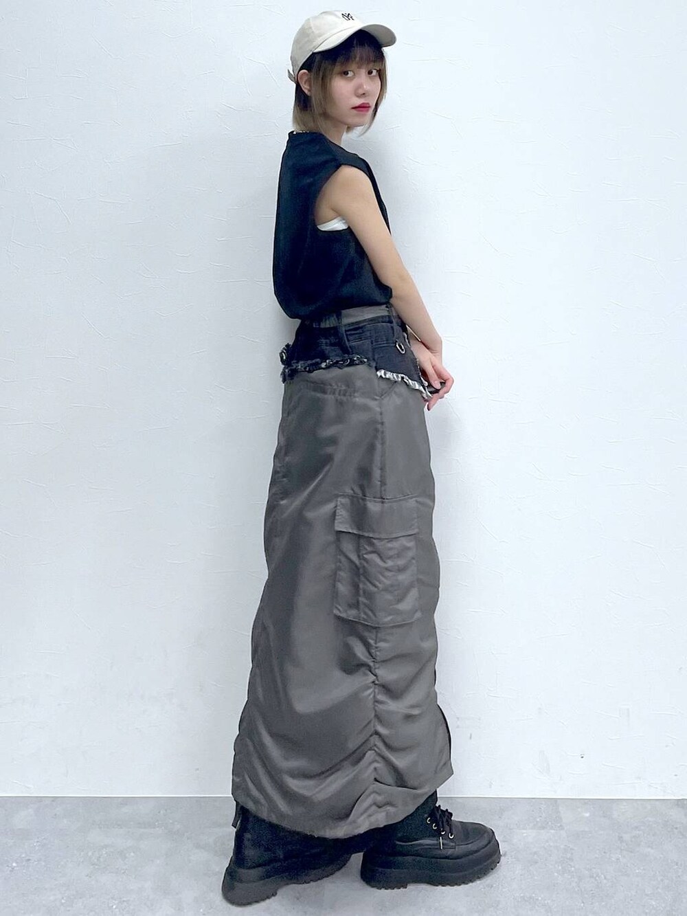 ブラック系のスラックス、ブラック系のTシャツ/カットソー、ブラック系のブーツを着用したレディースの春コーディネートの3枚目の写真