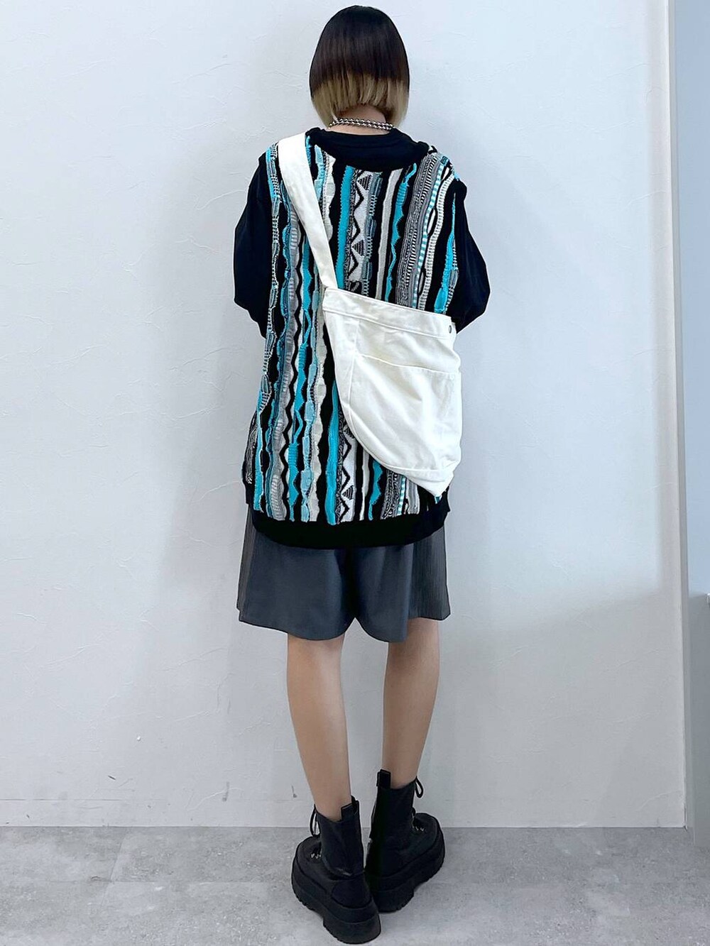 グレー系のスラックス、ブラック系のTシャツ/カットソー、ブラック系のブーツを着用したレディースの春コーディネートの5枚目の写真