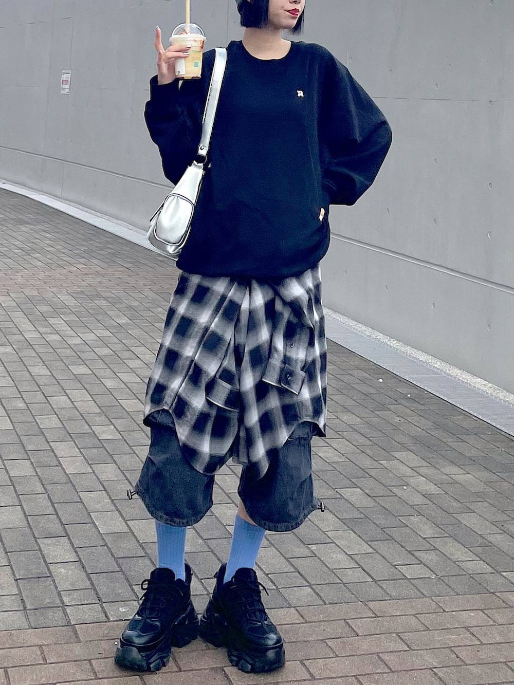 ブラック系のスニーカー、ブラック系のシャツ/ブラウス、ブラック系のデニムパンツを着用したレディースの秋コーディネートの5枚目の写真