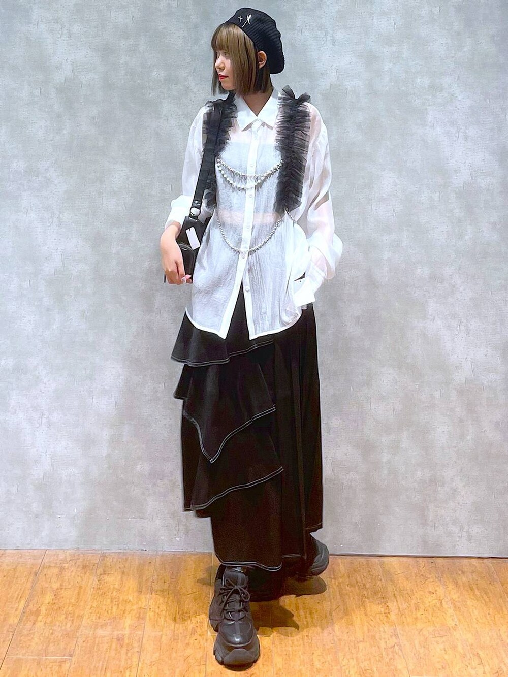 ブラック系のスニーカー、ホワイト系のシャツ/ブラウス、ブラック系のショルダーバッグを着用したレディースの秋コーディネートの4枚目の写真