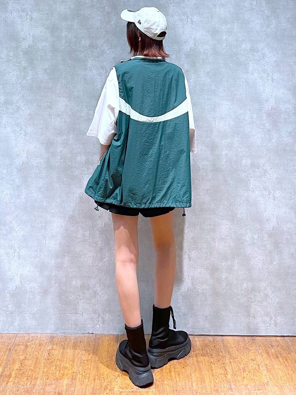 グリーン系のベスト、ホワイト系のTシャツ/カットソー、ブラック系のその他パンツを着用したレディースの春コーディネートの6枚目の写真