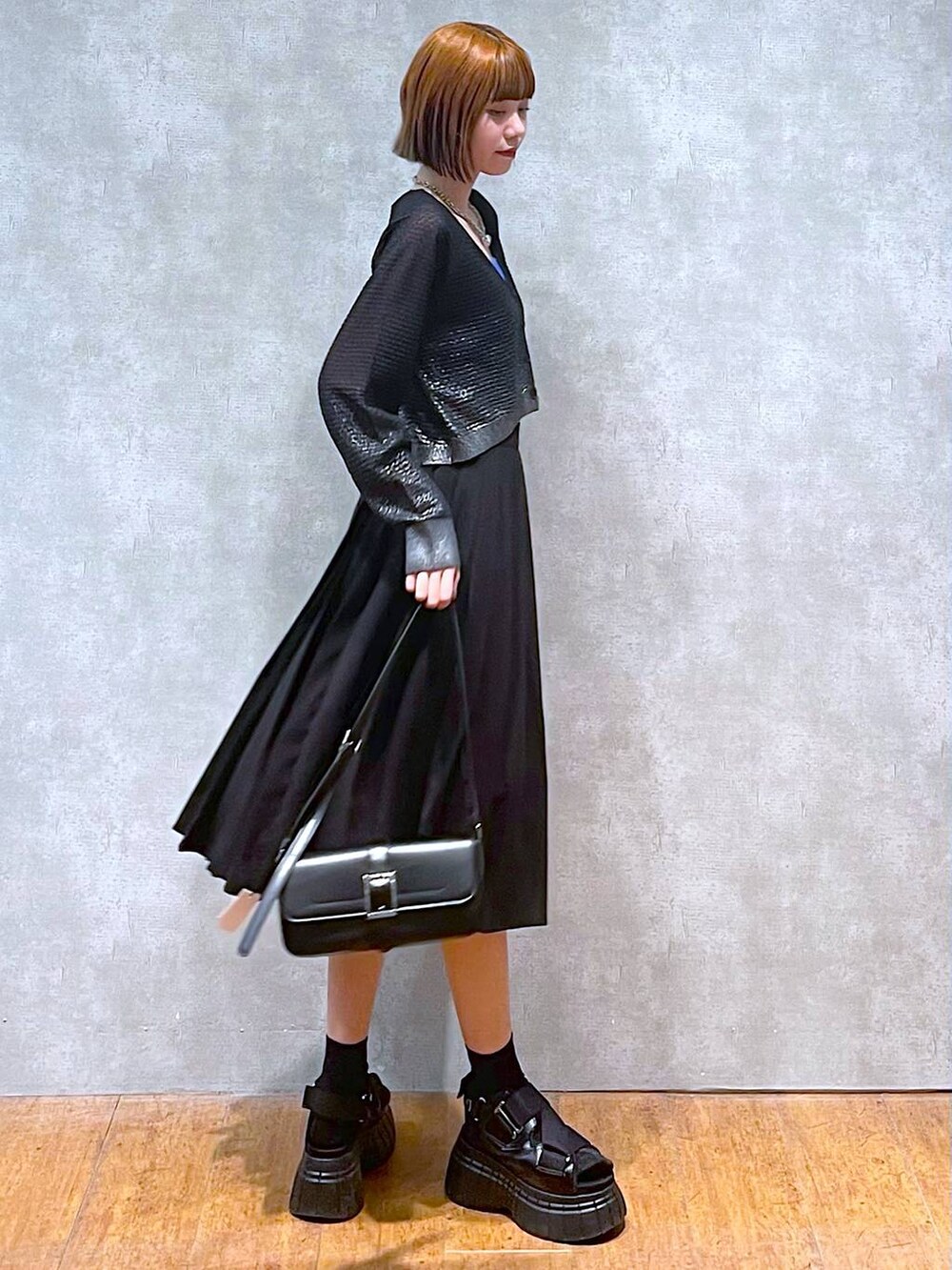 ブラック系のスニーカー、ブルー系のタンクトップ、ブラック系のスカートを着用したレディースの夏コーディネートの5枚目の写真