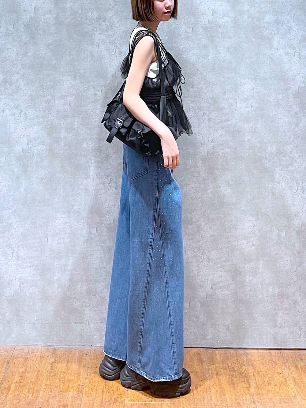 ブラック系のショルダーバッグ、ブラック系のスニーカー、ブラック系のベストを着用したレディースの夏コーディネートの3枚目の写真