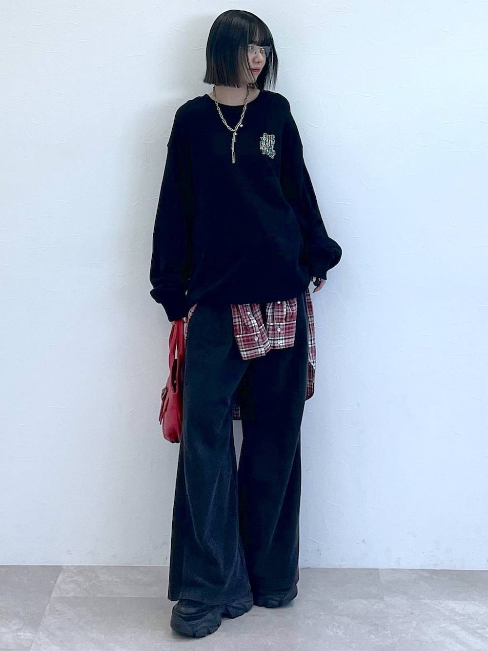 ブラック系のスニーカー、レッド系のシャツ/ブラウス、レッド系のハンドバッグを着用したレディースの秋コーディネートの2枚目の写真