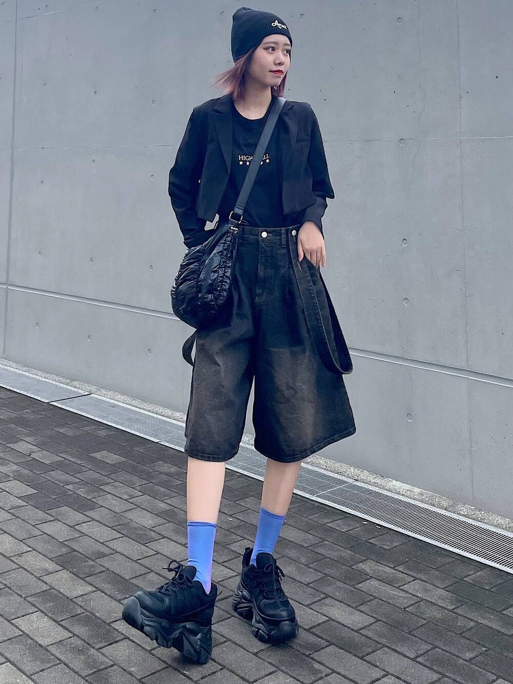 ブラック系のショルダーバッグ、ブラック系のスニーカー、ブラック系のTシャツ/カットソーを着用したレディースの春コーディネートの3枚目の写真