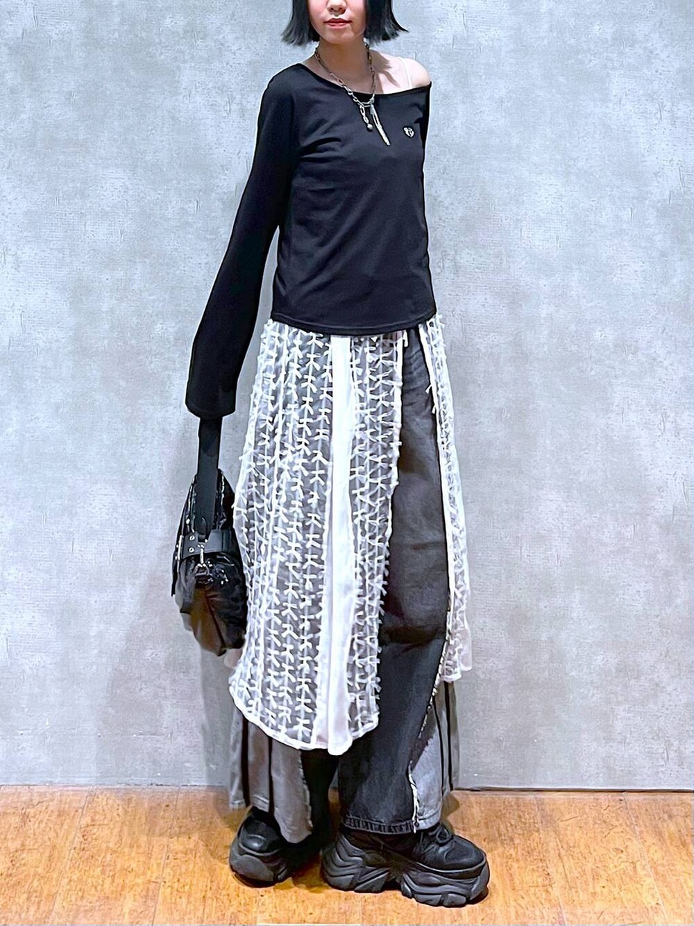 ブラック系のスニーカー、ブラック系のデニムパンツ、ブラック系のショルダーバッグを着用したレディースの夏コーディネートの5枚目の写真