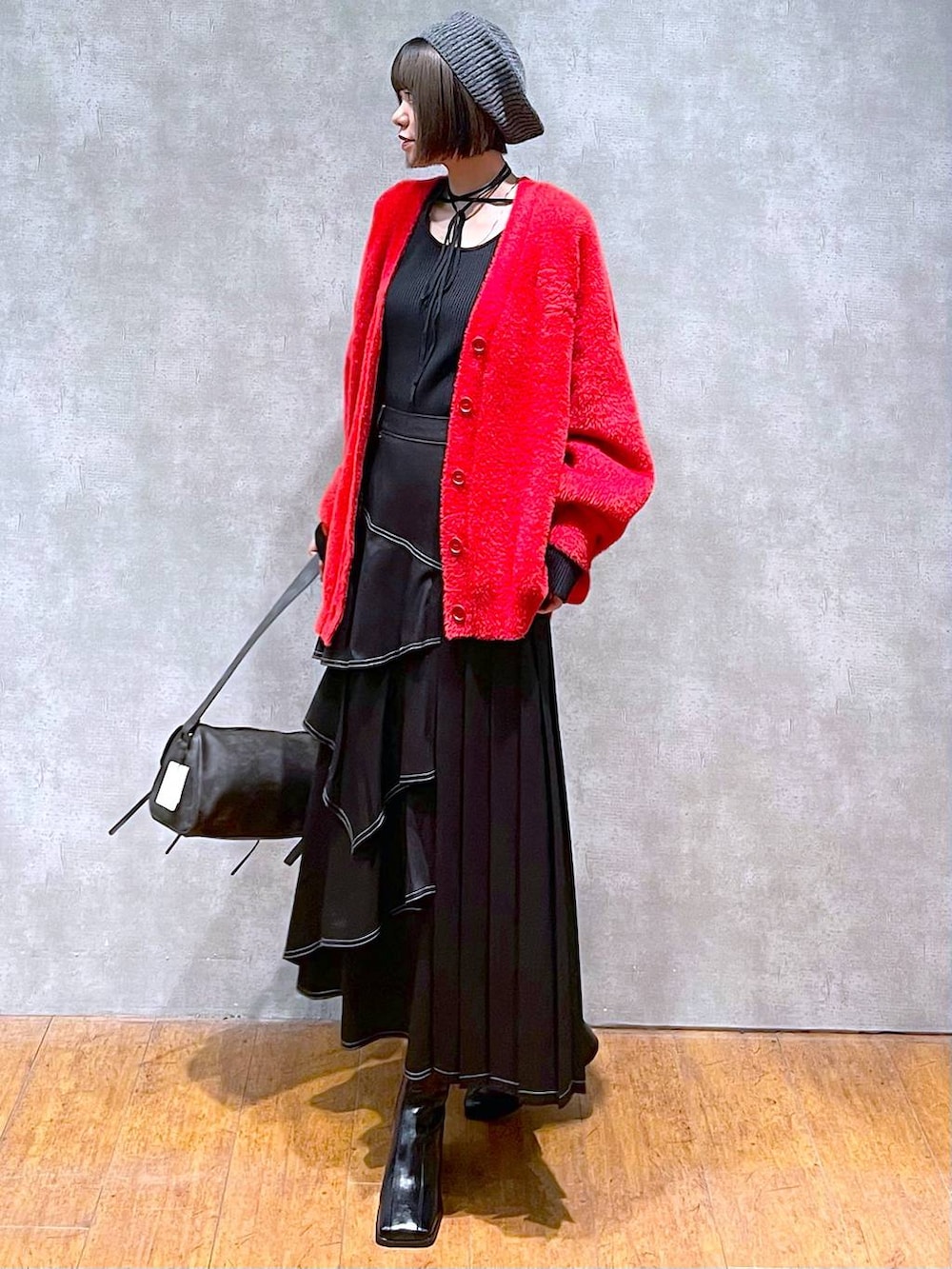 ブラック系のショルダーバッグ、ブラック系のブーツ、ブラック系のスカートを着用したレディースの秋コーディネートの2枚目の写真